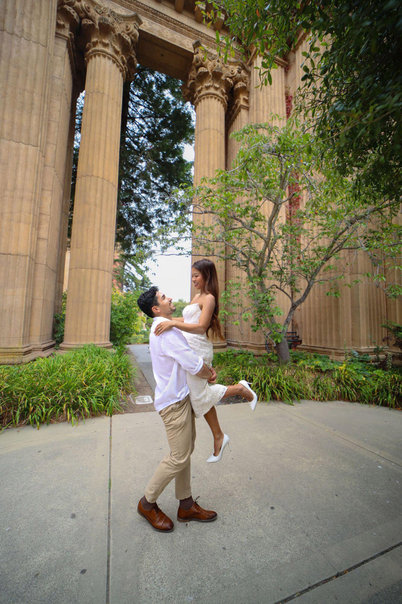 Juan Pablo lifting Trinique among tall stone columns, both smiling at each other